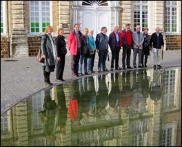De deelnemers aan de excursiedag poseren bij de spiegelvijver van de abdij Averbode.